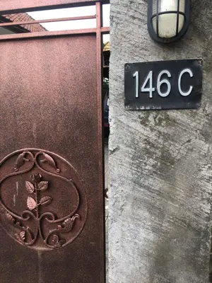 a sign on the side of a building with a iron gate at Simple apartment 1 Number 146 c in Seminyak
