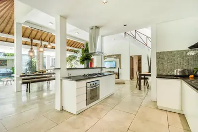 an open kitchen with white appliances and a dining room at Villa Malou in Seminyak