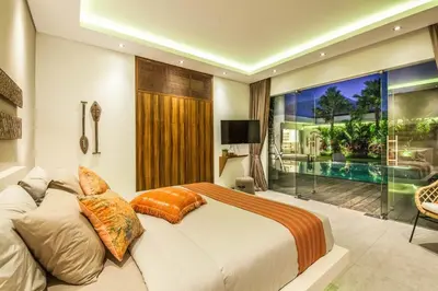 a bedroom with a large bed and a swimming pool at Stunning 6 Bedroom Villa Only 400m to the Beach in Canggu
