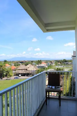 a balcony with a laptop sitting on a table at Paragon Hotel Seminyak in Seminyak