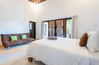 a white bedroom with a large bed and a couch at Alex Villas Coco - Seminyak in Seminyak