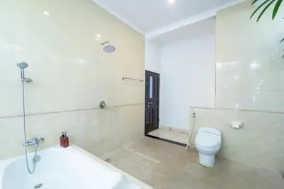 a bathroom with a tub and a toilet and a sink at Alex Villas Coco - Seminyak in Seminyak