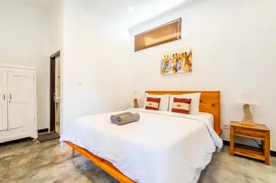 a bedroom with a large white bed and a table at Alex Villas Coco - Seminyak in Seminyak
