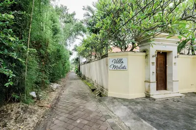 a wall with a sign on it next to a road at Villa Melati - Seminyak in Seminyak