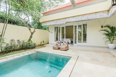 a swimming pool in front of a house at Villa Melati - Seminyak in Seminyak