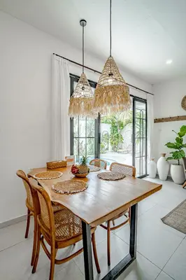 a dining room with a wooden table and chairs at Villa Lemone 3 by Bali Villa Solutions in Seminyak