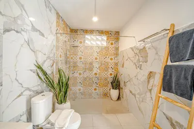 a bathroom with a shower and a toilet and plants at Villa Lemone 3 by Bali Villa Solutions in Seminyak
