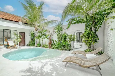 a backyard with a swimming pool and chairs and a house at Villa Lemone 3 by Bali Villa Solutions in Seminyak