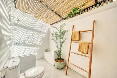 a bathroom with a toilet and a plant at Villa Arca Seminyak by Santi Management in Seminyak