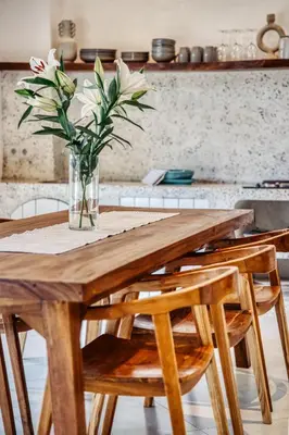 a wooden table with a vase of flowers on it at Villa Arca Seminyak by Santi Management in Seminyak
