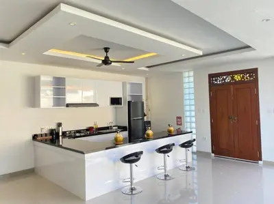 a kitchen with a counter and two bar stools at Villa Akmali Umalas 2BR with Private Pool & Jacuzzi in Canggu