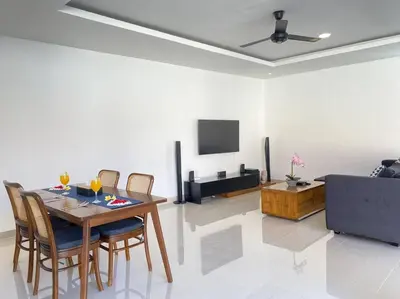 a living room with a table and chairs and a tv at Villa Akmali Umalas 2BR with Private Pool & Jacuzzi in Canggu