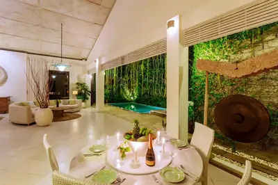 a living room with a green wall with a pool at Villa Casabola - Seminyak in Seminyak