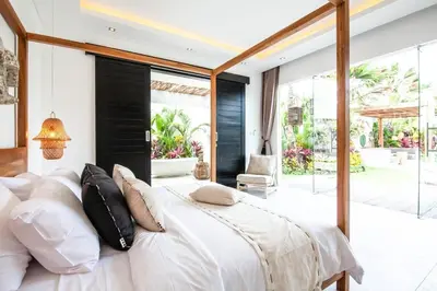 a bedroom with a large bed with white sheets and pillows at Modern 4 BR Villa 400m to the Beach in Canggu in Canggu