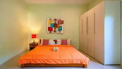a bedroom with a bed with an orange bedspread at Villa Harmony - Seminyak in Seminyak