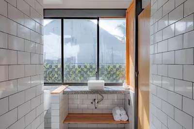 a bathroom with a window with a laptop on a counter at Town House CAMY in Seminyak