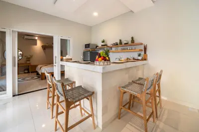 a kitchen and dining room with a counter and chairs at Villa Della One in Seminyak