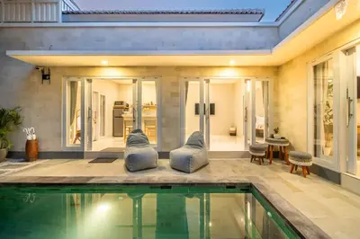 a house with a swimming pool and a living room at Villa Della One in Seminyak