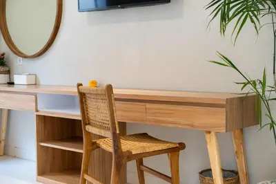 a wooden desk with a chair and a mirror at Villa Della One in Seminyak