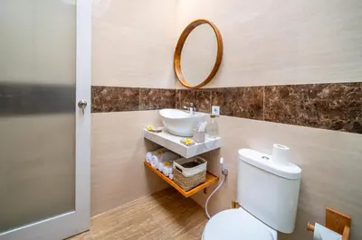 a bathroom with a sink and a toilet and a mirror at Villa Della One in Seminyak