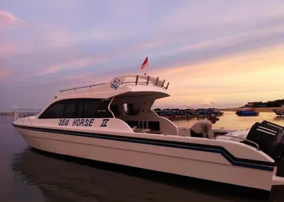 a man is standing on a boat in the water at Private Yacht Bali to Nusa Penida in Ujung