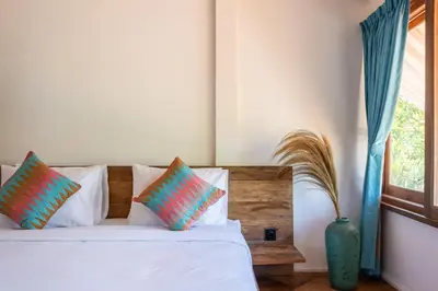 a bedroom with a white bed with pillows and a window at 2 BDR villa, walking distance to Seminyak beach. in Seminyak