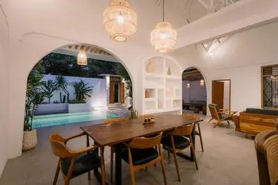 a dining room with a wooden table and chairs at Villa Batu Putih Seminyak in Seminyak