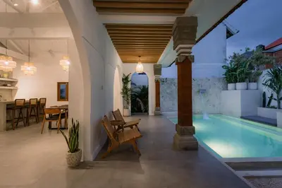 a villa with a swimming pool and a dining area at Villa Batu Putih Seminyak in Seminyak