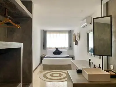 a bedroom with a bed and a large window at Alami Apartment Seminyak in Seminyak