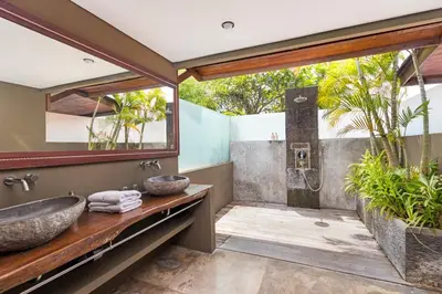 a bathroom with a stone sink and a shower at Villa Yoga by Villa Finder in Seminyak