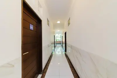 a hallway with a wooden door and a staircase at RedDoorz at Lotus House Seminyak in Seminyak