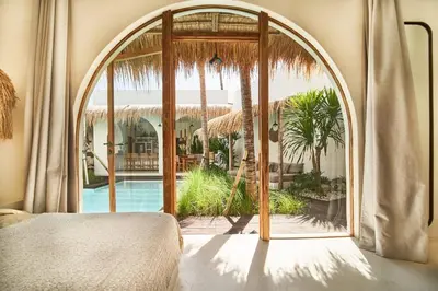 a bedroom with a large glass door to a pool at Gorgeous Mediterranean Style 2 Bed, Top Pick! in Canggu