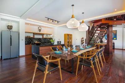 a kitchen and dining room with a wooden table and chairs at Villa Tramonto By Le Cielo in Canggu