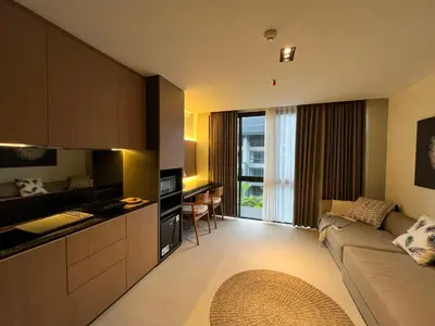 a kitchen and living room with a couch and a table at Cozy Minimalist Apartment Lavaya N511 in Nusa Dua