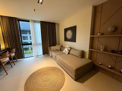 a living room with a couch and a large window at Cozy Minimalist Apartment Lavaya N511 in Nusa Dua