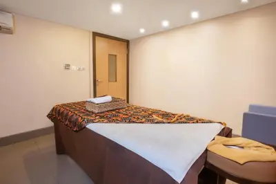a hospital room with a bed and a chair at de Vins Sky Hotel Seminyak in Seminyak