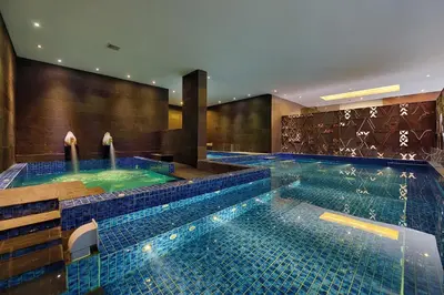 a swimming pool with two jacuzzles in a hotel at de Vins Sky Hotel Seminyak in Seminyak