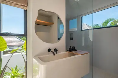 a bathroom with a sink and a mirror at Berawa Breeze - Chic 4BR Beachside Oasis with Sauna in Canggu