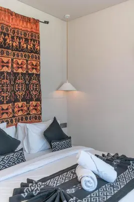 a bedroom with a bed with towels on it at Berawa Breeze - Chic 4BR Beachside Oasis with Sauna in Canggu