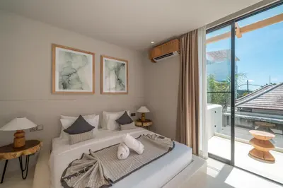 a bedroom with a bed and a large window at Berawa Breeze - Chic 4BR Beachside Oasis with Sauna in Canggu
