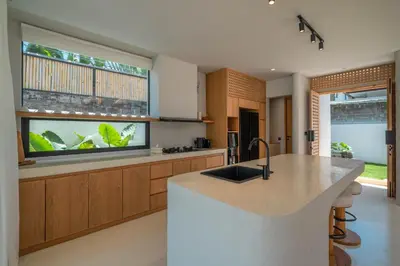 a kitchen with a large window and a fish tank at Berawa Breeze - Chic 4BR Beachside Oasis with Sauna in Canggu