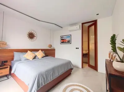 a bedroom with a large bed and a table at Cosy Haven 2 BR Villa in Umalas in Canggu