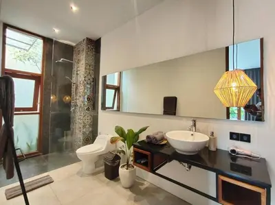 a bathroom with a sink and a toilet and a mirror at Cosy Haven 2 BR Villa in Umalas in Canggu