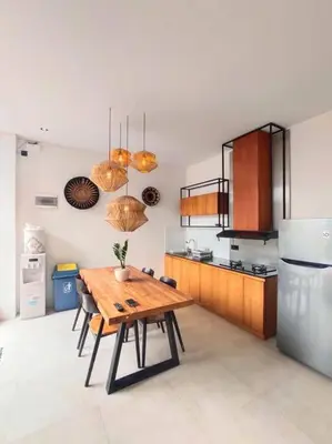 a kitchen with a wooden table and a refrigerator at Cosy Haven 2 BR Villa in Umalas in Canggu