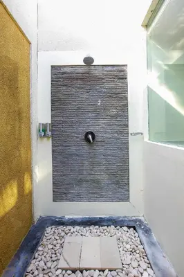 a bathroom with a shower with a stone floor at 1 Bed Room Villa In Seminyak in Seminyak