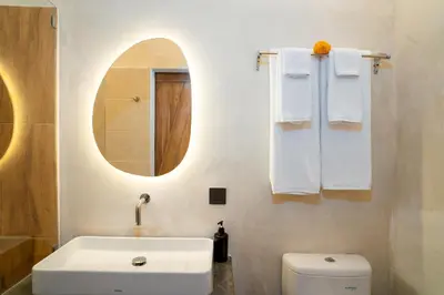 a bathroom with a sink and a toilet and a mirror at Alaya Homes A - Luxury Japandi Loft Suite in Seminyak in Seminyak