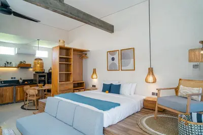 a bedroom with a large bed and a kitchen at Alaya Homes A - Luxury Japandi Loft Suite in Seminyak in Seminyak