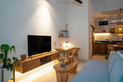 a living room with a blue couch and a flat screen tv at Alaya Homes A - Luxury Japandi Loft Suite in Seminyak in Seminyak