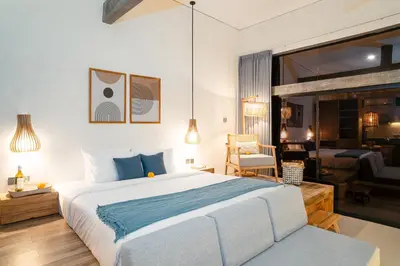 a bedroom with a large bed and a living room at Alaya Homes A - Luxury Japandi Loft Suite in Seminyak in Seminyak