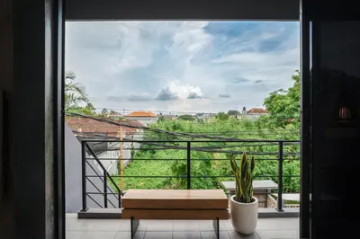 a balcony with a bench and a view of a field at Alaya Homes C - Elegant Japandi Loft Suite in Seminyak in Seminyak